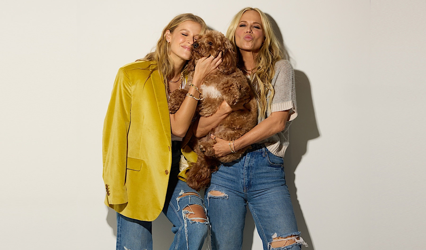 Two models holding a dog